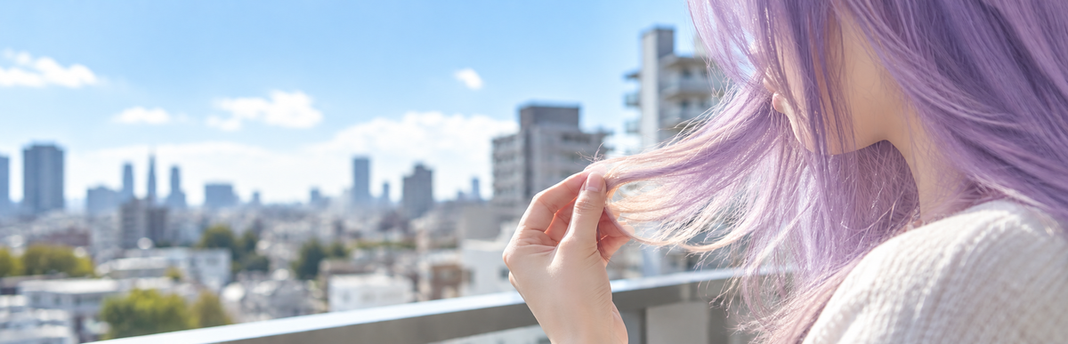 紫が抜けていく途中の髪色を自然光で確かめるイメージ
